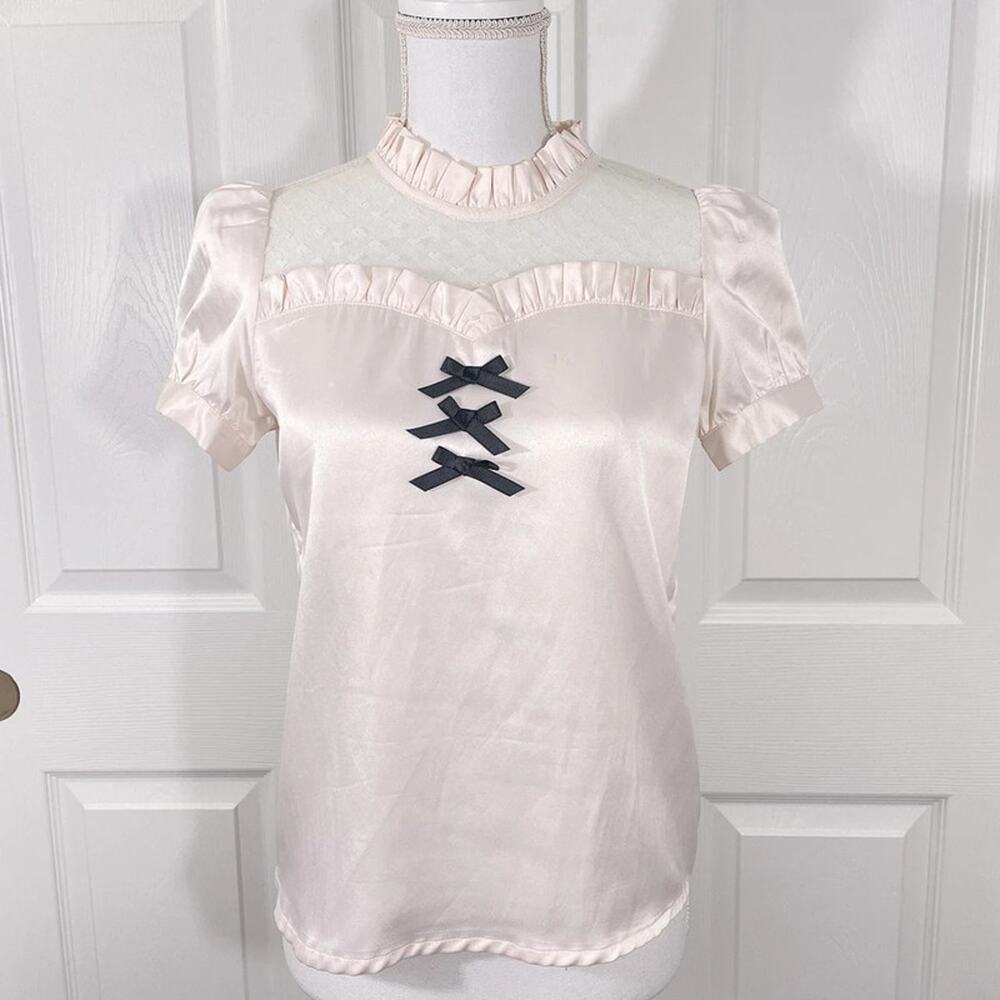 The most darling pastel pink ruffle blouse with black ribbons